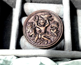 Bottone putto con pappagallino e fede nuziale. Antico. Diametro 3 cm.