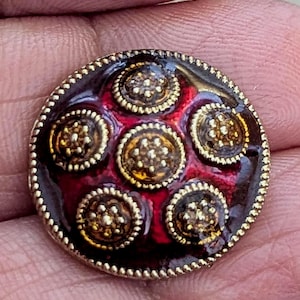 Bouton émaillé rouge avec cercles façon ambre doré. 1,5 cm de diamètre.