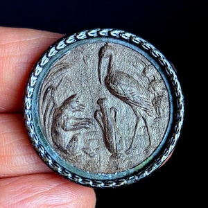 Button of Aesops Fables mythology/story/ in wood veneer and metal casing. 3.2cm diameter.