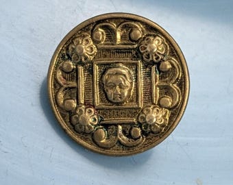 Antico bottone raffigurante un cherubino in una finestra. Diametro 1,6 cm.