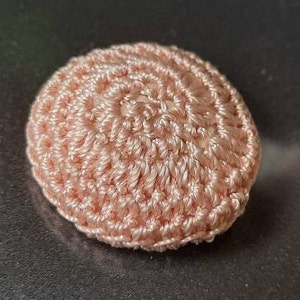 May include: A close-up of a pink crocheted circle, possibly a coaster or a decorative element.