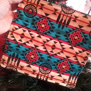 May include: A teal, red, black and white patterned fabric pot holder with a dreamcatcher design.