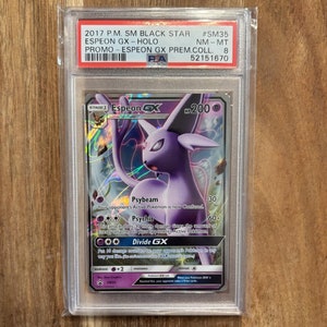 May include: A graded Pokemon trading card featuring Espeon GX from the SM Black Star Promo set. The card is in near mint condition and has a holographic finish.