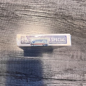 Puede incluir: Una baraja de cartas con un dise&ntilde;o azul y blanco. La caja est&aacute; envuelta en pl&aacute;stico y tiene el texto "Bicycle Special" impreso.