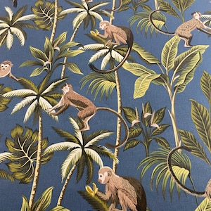May include: A blue fabric with a repeating pattern of monkeys swinging from palm trees. The monkeys are brown and have long tails. The palm trees have green leaves and brown trunks. The background is a solid blue colour.