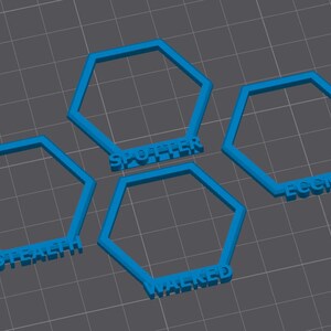 May include: Four bright blue, open-frame hexagonal shapes arranged on a dark gray grid. Each hexagon features raised, embossed lettering along the bottom edge, displaying the words STEALTH, SPOTTER, WALKED, and ECEM in a bold, sans-serif font.