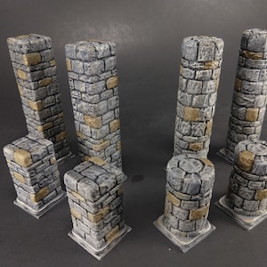 Puede incluir: Conjunto de ocho columnas de piedra gris y marrón, algunas altas y otras bajas, para juegos de mesa o escenografía en miniatura.
