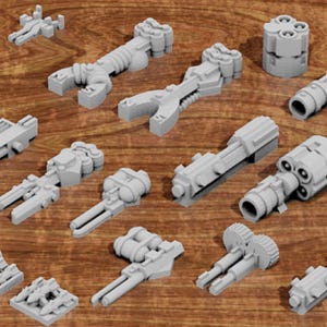 May include: A collection of gray, 3D-printed miniature weapon models, including various guns, barrels, and other components. The models are arranged on a wooden surface, showcasing a variety of designs and sizes, perfect for tabletop gaming or model building.