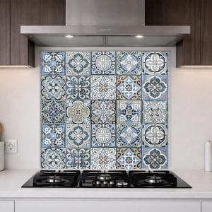 May include: A square kitchen backsplash panel featuring a grid of twenty decorative tiles. Each tile displays a unique, intricate geometric and floral pattern in a color palette of muted blue, grey, cream, and dark brown, arranged in a symmetrical layout.