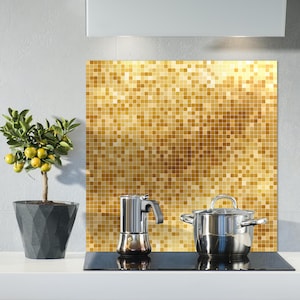 May include: A kitchen scene featuring a small potted lemon tree, a stainless steel stovetop espresso maker, and a stainless steel pot with a lid. A gold mosaic backsplash is behind the appliances.