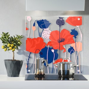May include: A kitchen scene featuring a decorative glass panel with a poppy flower design in red, blue, and white. A stainless steel pot and espresso maker sit on a black stovetop. A potted citrus tree is on the left.