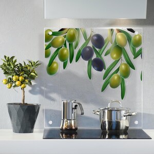 Könnte beinhalten: Eine Küchenszene mit einer Glas-Spritzschutzwand mit einem Olivenzweig-Design mit grünen und schwarzen Oliven. Ein kleiner Topf mit einer Pflanze, ein Edelstahltopf und eine Kaffeemaschine stehen auf der Theke.