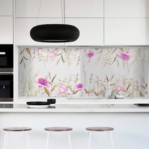 Könnte beinhalten: Eine moderne Küche mit weißen Schränken, einem schwarzen Backofen und einem schwarzen Wasserhahn. Das Fenster zeigt ein Blumenmuster mit rosa Blüten und beigen Blättern. Drei weiße Hocker mit Holzsitz vor der Theke.