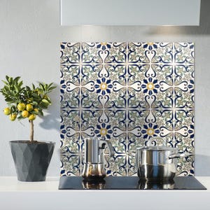 Puede incluir: Escena de cocina con un protector contra salpicaduras decorativo con un patrón de baldosas florales azules, verdes y amarillas. Un pequeño limonero en maceta a la izquierda. Una encimera de acero inoxidable con cafetera y olla.