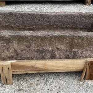 May include: A large, rectangular stone trough with rough, textured surfaces. The trough is a muted brown color and sits on a wooden pallet. The trough's interior is a deep, open space.