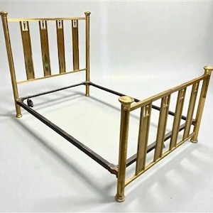 May include: A vintage brass bed frame with a headboard and footboard. The headboard and footboard feature vertical bars with decorative rectangular accents. The frame has a dark metal base and is set against a white background.