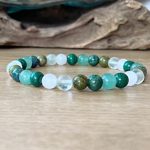 May include: A green, white, and brown beaded bracelet with a variety of stones. The bracelet is made of natural stones and is perfect for everyday wear.