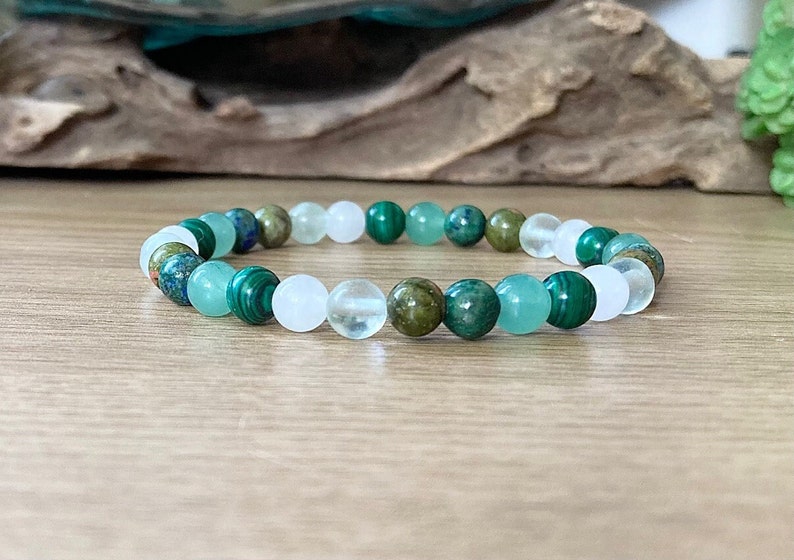 May include: A green, white, and brown beaded bracelet with a variety of stones. The bracelet is made of natural stones and is perfect for everyday wear.