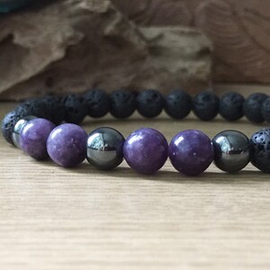 Close-up of lepidolite, hematite, and lava rock beads showing natural stone texture