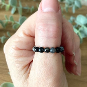 Peut inclure: Une bague en perles noires et grises avec des perles noires et grises alternées.