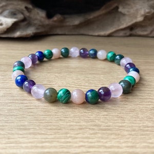 Peut inclure: Un bracelet en perles avec des pierres roses, vertes, bleues et violettes.