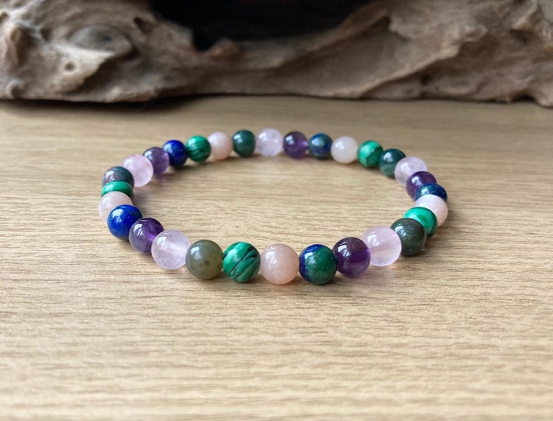 Peut inclure: Un bracelet en perles avec des pierres roses, vertes, bleues et violettes.