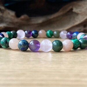 Peut inclure: Un bracelet en perles multicolores avec des perles roses, violettes, vertes et bleues. Le bracelet est fait de pierres naturelles.