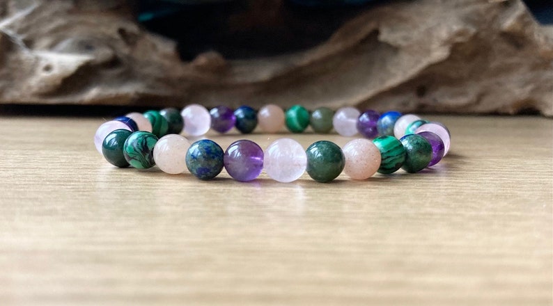 Peut inclure: Un bracelet en perles multicolores avec des perles roses, violettes, vertes et bleues. Le bracelet est fait de pierres naturelles.