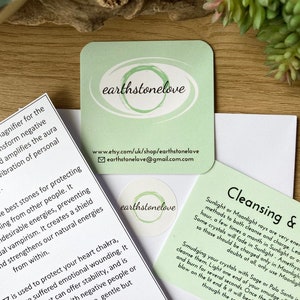 May include: Green card with the text "earthstonelove" and a website address. The card also includes instructions for cleansing crystals with sunlight or moonlight.