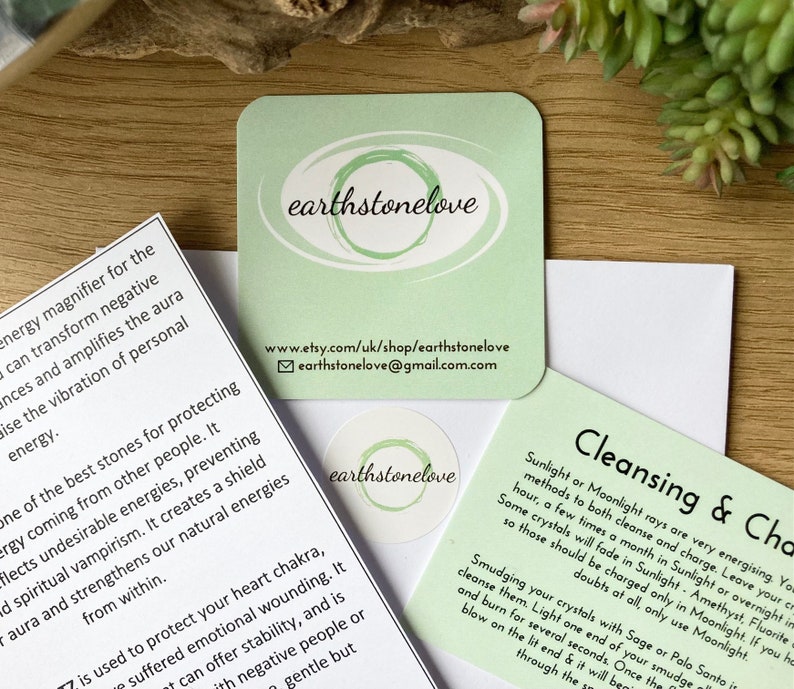 May include: Green card with the text "earthstonelove" and a website address. The card also includes instructions for cleansing crystals with sunlight or moonlight.