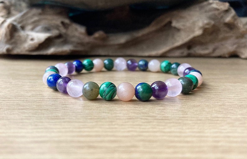 A semi precious beaded gemstone bracelet made with flexible strong stretch cord with crystals to help with all aspects of childbirth and post natal. It is made with 6mm moonstone, rose quartz, moss agate, malachite, amethyst, chrysocolla crystals.