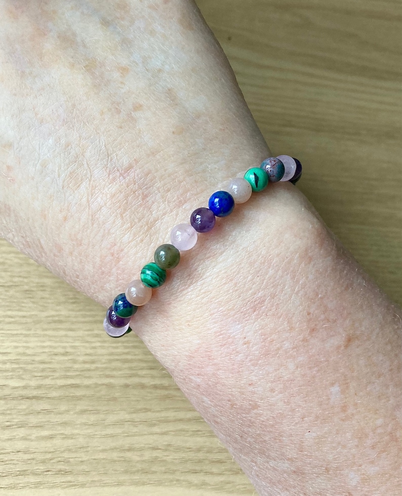 Peut inclure: Un bracelet en perles multicolores avec des perles vertes, roses, violettes et bleues.