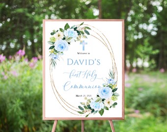 May include: A white sign with a gold glitter frame and blue floral design. The sign says "Welcome to David's First Holy Communion March 21, 2021".