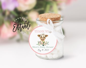 Puede incluir: Una etiqueta redonda de agradecimiento rosa y blanca con una ilustración de acuarela de un ternero marrón y blanco con una corona de flores. El texto en la etiqueta dice "Gracias" y "Baby Shower de Allison 10 de mayo de 2022".