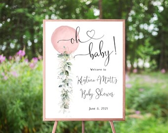 May include: A pink and white baby shower welcome sign with a watercolor balloon and greenery. The sign reads "Oh baby! Welcome to Kristina & Matt's Baby Shower June 8, 2021".