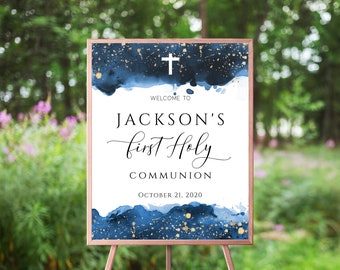 May include: Welcome to Jackson's First Holy Communion sign with a blue watercolour background and gold glitter accents. The date October 21, 2020 is printed below the text.