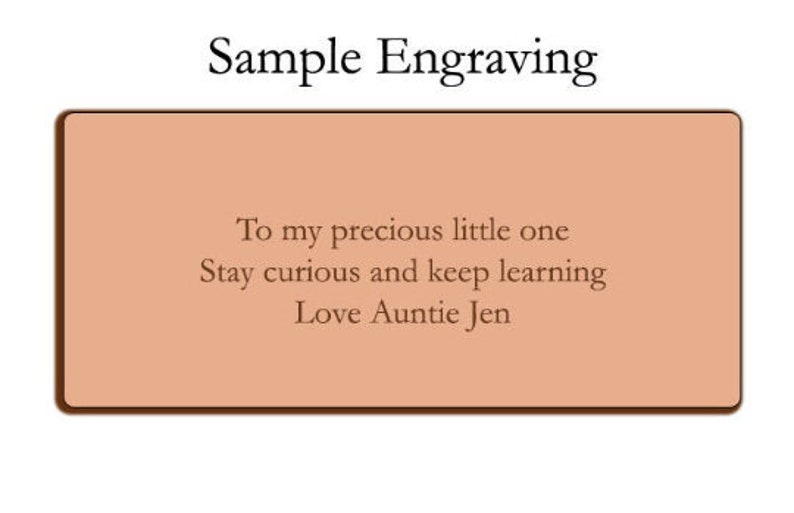 May include: A sample engraving on a light brown background with the text "To my precious little one Stay curious and keep learning Love Auntie Jen".
