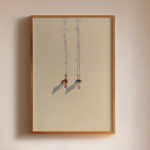 May include: A bedroom interior with framed art, a wooden headboard with shelves, and a bed with white bedding. The artwork includes a framed print of a cat and a framed print of two figures swinging. Decorative items include a black vase and small wooden spheres.