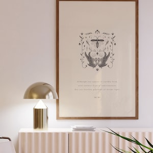 Może przedstawiać: Oprawiony wydruk z ilustracją inspirowaną naturą i tekstem Rumiego. Grafika przedstawia pszczołę, łabędzie i elementy kwiatowe w czerni i bieli. Złota lampa stoi na jasnoróżowej szafce.