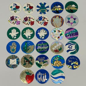 May include: A collection of round, colorful stickers with various designs and symbols. The stickers feature images of hearts, stars, hands, and text, including the word "Shabbat". The color palette includes blue, green, gold, and red.