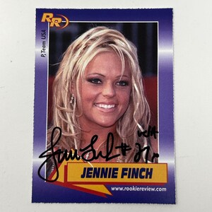 Peut inclure: Une carte de collection avec une femme blonde souriante aux longs cheveux. La carte a une bordure bleue et comprend le texte "Jennie Finch" et "www.rookiereview.com". La carte a également une signature.
