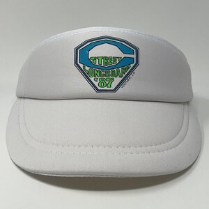 May include: A white visor with a curved brim. The visor features a logo with the words "Street Longboard '87" in teal and green, with a teal outline. The text "Ventura, CA" is also included.