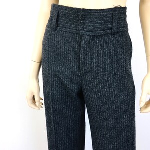 Puede incluir: Pantal&oacute;n gris de rayas finas con cintura alta y cintur&oacute;n ancho.