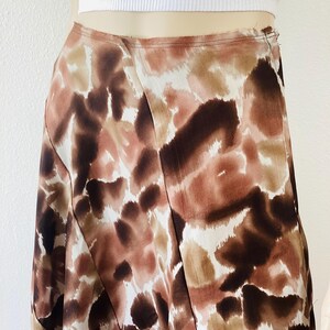 K&ouml;nnte beinhalten: Midirock mit abstraktem Muster in Braun-, Beige- und Wei&szlig;t&ouml;nen. Der Rock hat ein Wickeldesign und eine hohe Taille. Der Stoff wirkt leicht und flie&szlig;end, ideal f&uuml;r w&auml;rmeres Wetter.