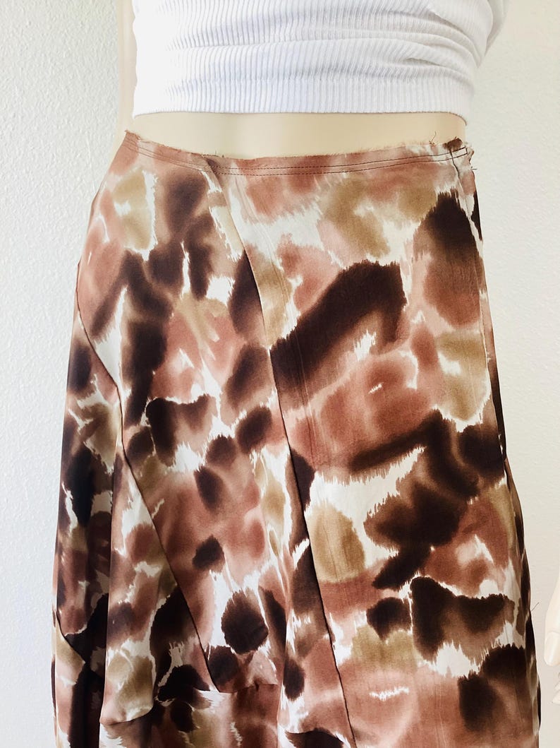 K&ouml;nnte beinhalten: Midirock mit abstraktem Muster in Braun-, Beige- und Wei&szlig;t&ouml;nen. Der Rock hat ein Wickeldesign und eine hohe Taille. Der Stoff wirkt leicht und flie&szlig;end, ideal f&uuml;r w&auml;rmeres Wetter.