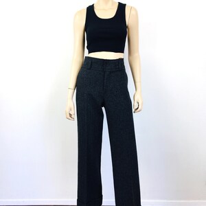 Puede incluir: Pantal&oacute;n de rayas blancas y negras con cintura alta y dobladillo vuelto. El pantal&oacute;n est&aacute; en un maniqu&iacute;.