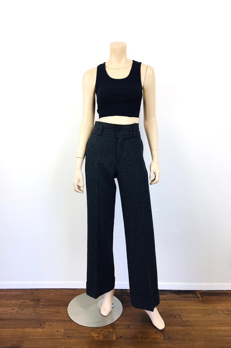 Puede incluir: Pantal&oacute;n de rayas blancas y negras con cintura alta y dobladillo vuelto. El pantal&oacute;n est&aacute; en un maniqu&iacute;.