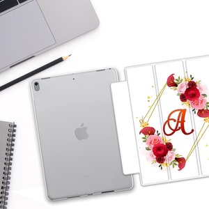 May include: A white iPad case featuring a floral design with the letter "A" in the centre. The flowers are red, pink and white.