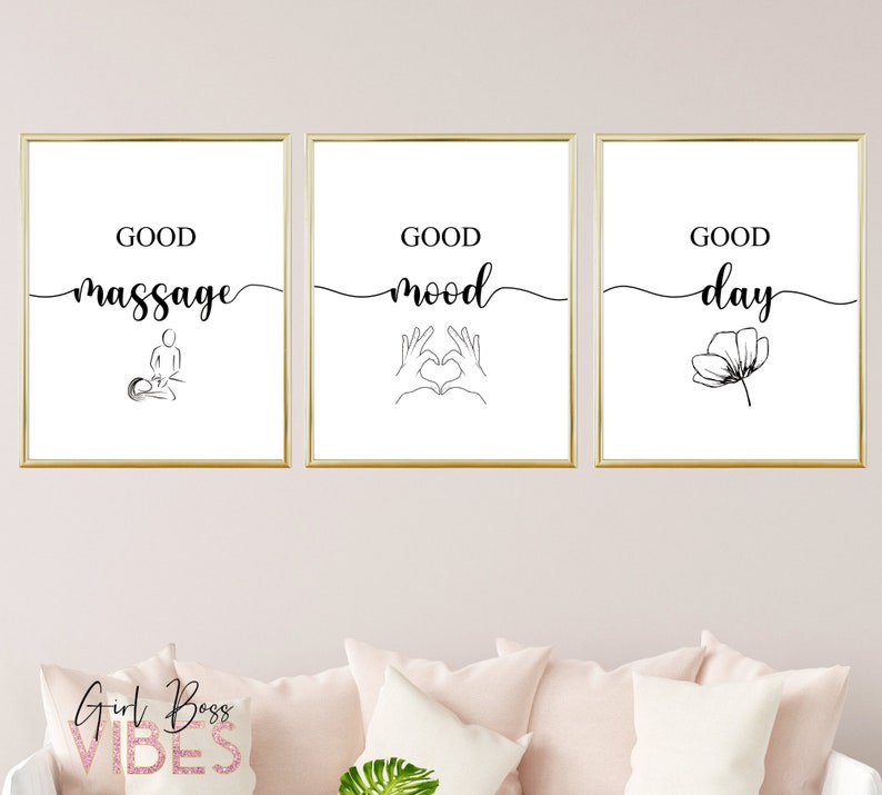 May include: Three black and white minimalist prints with gold frames. The prints feature the text "Good massage", "Good mood", and "Good day" with simple line drawings of a person getting a massage, hands making a heart shape, and a flower.
