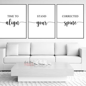 May include: Three black framed prints with white backgrounds and black calligraphy text. The text reads "Time to align", "Stand your", and "Corrected spine".